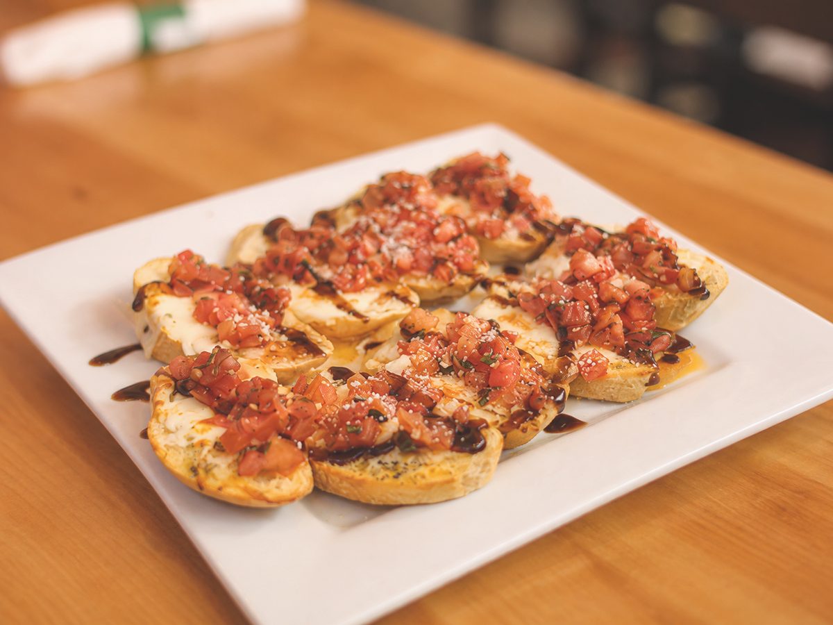 Bruschetta on homemade garlic bread with diced tomato and balsamic glaze