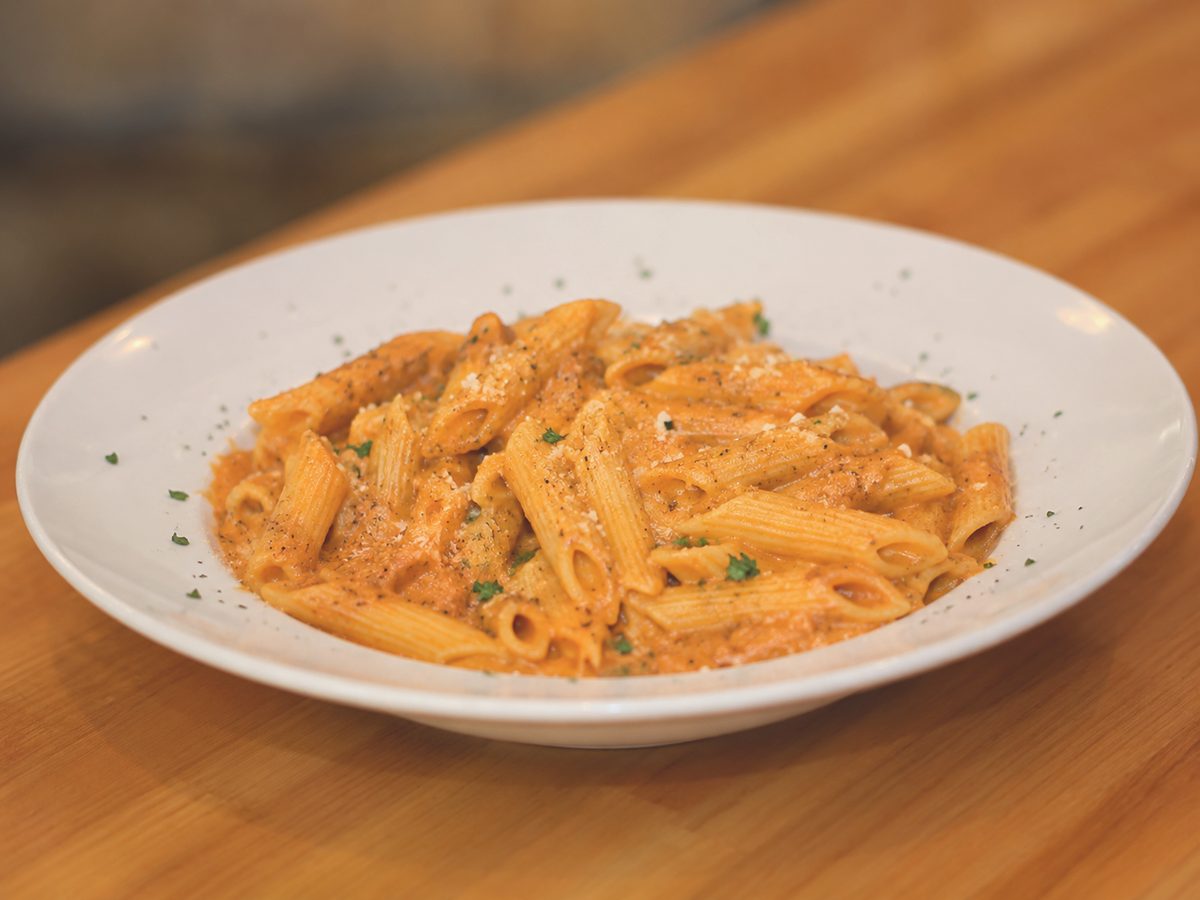 Penne alla vodka in a creamy pink sauce, finished with parsley and parmesan